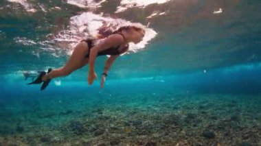 Genç, sıska kadın daldı dalgaların altına