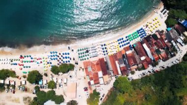 Brezilya kıyısında, Paraty kasabasında şemsiyeli ve binalı bir sahil.