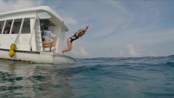 若いフィットスリム女性はボートから海にダイブ — ストック動画