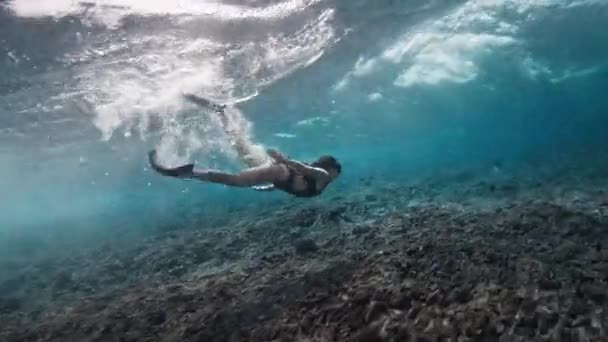 若いフィットスリム女性は壊れた波の下でダイビング — ストック動画