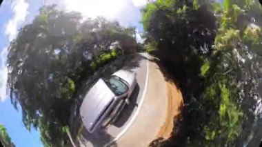 Araba mükemmel manzaralı bir yolda gidiyor. Ağaçlarla kaplı araba yolda ilerliyor.