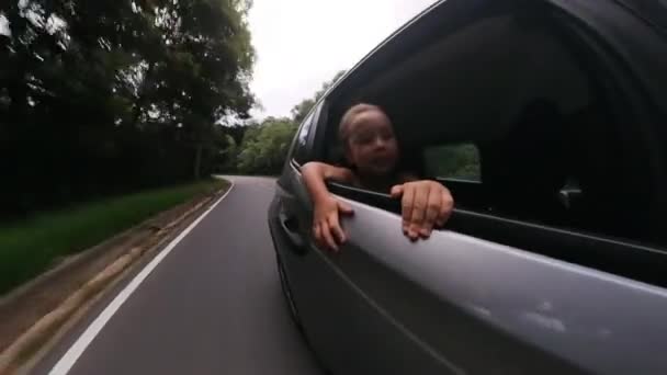 Menina Criança Viaja Carro Observa Estrada Janela Aberta Apreciando Fluxo — Vídeo de Stock