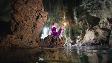 Mağara dalışı. Freediver su altında yüzüyor ve Batı Papua, Endonezya 'daki mağaranın karmaşık labirentlerini keşfediyor.