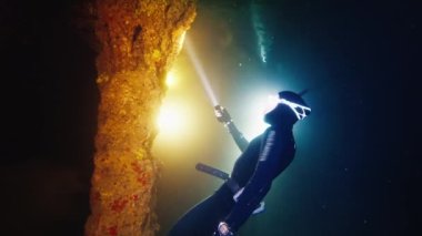 Mağara dalışı. Freediver su altında yüzüyor ve Batı Papua, Endonezya 'daki mağaranın karmaşık labirentlerini keşfediyor.