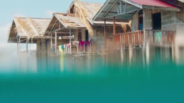 Papua 'da tatil köyü, Raja Ampat, Endonezya. Su altı, Misool 'daki basit bir otel olan Raja Ampat' ı ikiye böldü.