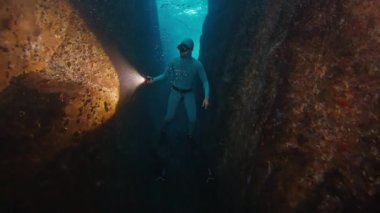 Freediver denizde suyun altında yüzer. İnsan kurtarıcı sualtı kanyonunda süzülür ve onu meşaleyle keşfeder.
