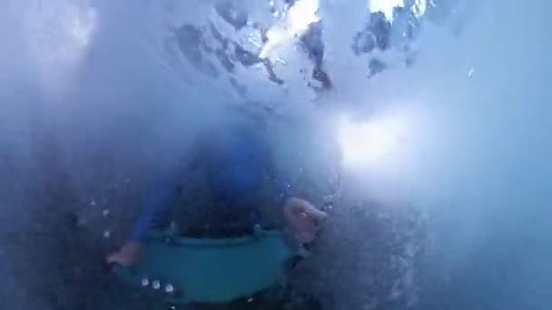 水中写真家は 波を破って海の岩の間に絞られた非常に荒い状態でカメラで泳ぎます — ストック動画