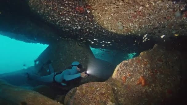 Freediver Swims Underwater Sea Explores Cave Torch — Stock Video