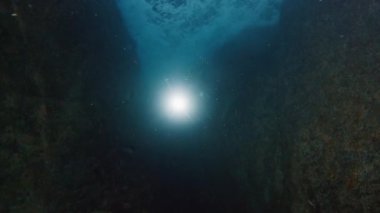 Freediver denizde suyun altında yüzer. İnsan kurtarıcı sualtı kanyonunda süzülür ve onu meşaleyle keşfeder.