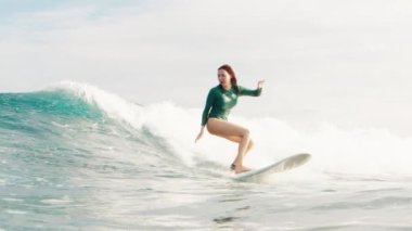 Kadın sörfçü Maldivler 'de okyanusta dalgalarda sörf yapıyor.