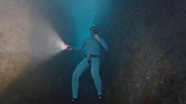 Freediver denizde suyun altında yüzer. İnsan kurtarıcı sualtı kanyonunda süzülür ve onu meşaleyle keşfeder.