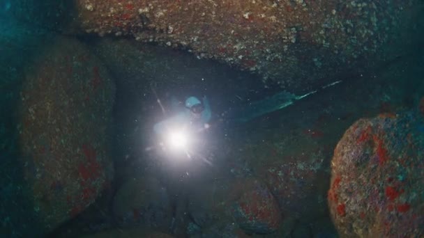Фридайвер Плавает Водой Море Исследует Пещеру Факелом — стоковое видео