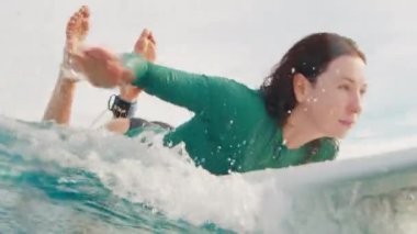 Kadın sörfçü Maldivler 'de okyanusta dalgalarda sörf yapıyor.