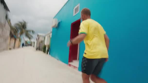 穿着黄色衬衫的男子赤脚在亚洲小镇的街道上奔跑 — 图库视频影像