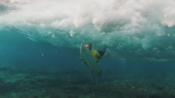 在马尔代夫 穿着黄色衬衫的冲浪手和冲浪板在海浪中潜水 — 图库视频影像
