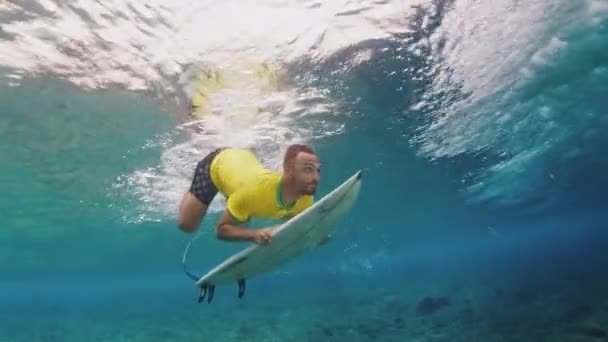Surfer Żółtej Koszuli Nurkuje Pod Falą Deską Surfingową Malediwach — Wideo stockowe