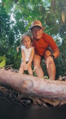 Çocuklar için orman bilimi. Baba ve kızı ormanı keşfederler ve yerde koşan karıncaları izlerler.