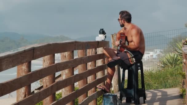 Florianopolis Campeche Brazil 2024年3月20日 巴西男子日出时在海滩上弹奏吉他和喝咖啡 — 图库视频影像
