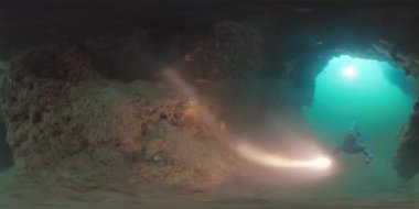 Freediver 'ın görüntüsü. Serbest yüzücü adam meşaleyle su altında yüzüyor ve Endonezya 'nın Batı Papua bölgesini keşfediyor.