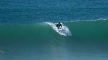 FLORIANOPOLIS, BRAZİL - 25 Mart 2024: Sörfçü dalgayı Santa Catarina adasındaki Morro das Pedras adasında sürüyor