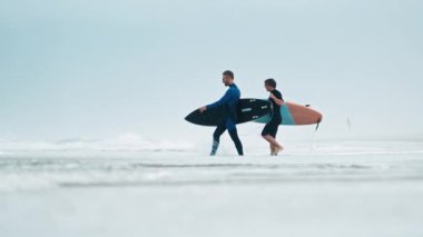 Sörf tahtalı sörfçüler sisli bir sabahta okyanusa girerler.