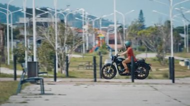 FLORIANOPOLIS, BRAZİL - 30 Mart 2024: Adam Brezilya 'da sokakta siyah Royal Enfield Classic 350 motosikletine biniyor