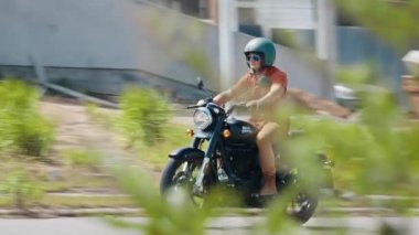 FLORIANOPOLIS, BRAZİL - 30 Mart 2024: Adam Brezilya 'da sokakta siyah Royal Enfield Classic 350 motosikletine biniyor