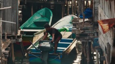 YELLU, MISOL, INDONEZYA-NOVEMBER 22, 2023 - İnsan ayaklıklar üzerindeki geleneksel binalarda ev işleri yapar