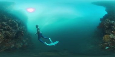 Endonezya 'nın Raja Ampat bölgesindeki sağlıklı mercan resiflerinde yüzen erkek serbest dalgıcın VR 360 su altı görüntüleri. Clip 'in yerel sesi var