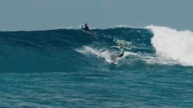HURAA, MALDIVES - 21 Temmuz 2024: Erkek sörfçü Maldivler 'de büyük okyanus dalgalarına biniyor