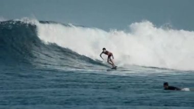HURAA ADASI, MALDIVES - 20 Temmuz 2024: Deneyimli sörfçü Maldivler 'in kuzey atollerinde ünlü Sultanların sörf noktasında okyanus dalgasına biniyor