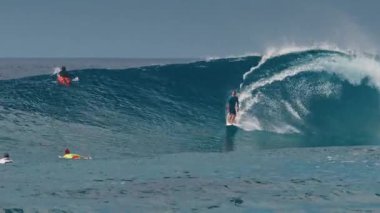 HURAA ADASI, MALDIVES - 20 Temmuz 2024: Deneyimli sörfçü Maldivler 'in kuzey atollerinde ünlü Sultanların sörf noktasında okyanus dalgasına biniyor