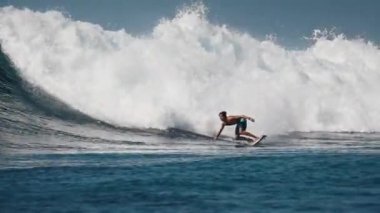 HURAA ADASI, MALDIVES - 20 HAZİRAN 2024: Genç erkek sörfçü Maldivler 'de büyük bir dalgaya biniyor ve fıçıdan çıkıyor ve kaybolmuyor.