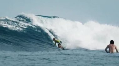 Gelişmiş erkek sörfçü Maldivler 'de okyanus dalgalarına biner ve dönüşler yapar.