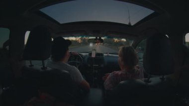 İki kişi arabayla seyahat ediyor. Genç adam ve yaşlı kadın arabayı sürüyor ve konuşuyorlar.