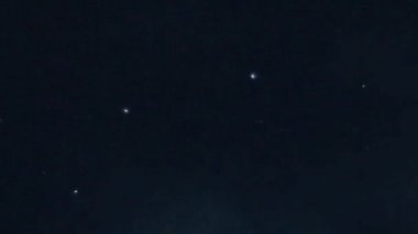 Aurora Borealis, doğal, gerçek hız görüntüsü. Gece gökyüzünde bazı bulutlar ve yıldızlarla kuzey ışıkları. Gökyüzünde bulutlarla şekillenen yeşil kuzey ışıklarının gürültülü bir görüntüsü.