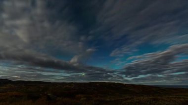 Aurora borealis zaman aşımı. Gece gökyüzündeki kuzey ışıkları Bulutlar ve ay ile