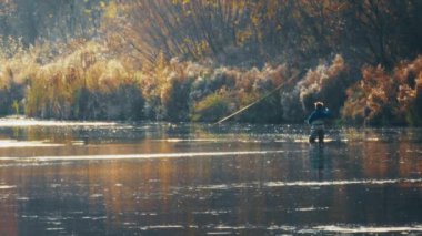 Sonbahar sineği avı. Amatör balıkçı sineği yavaş çekimde fırlatıyor.
