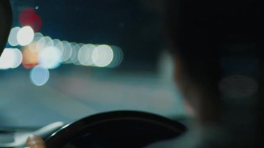 Gece yolculuğu. Aydınlatılmış boş otoyolda geceleyin direksiyon sallayan kişi. Sürücünün otobanda araba sürüşünün iç görüntüsü.