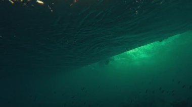 Maldivler 'de kıyıda kırılan okyanus dalgalarının sualtı görüntüsü.
