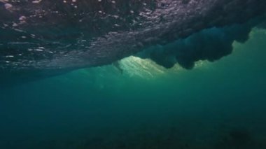 Maldivler 'de kıyıda kırılan okyanus dalgalarının sualtı görüntüsü.