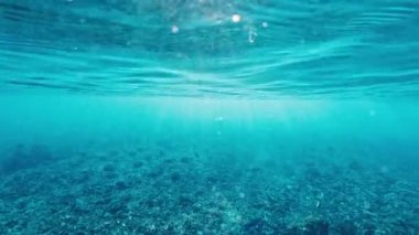 Gün doğumunda denizdeki sakin su yüzeyinin sualtı görüntüsü