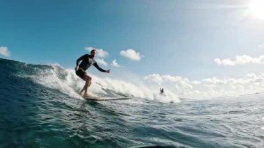 Sörfçü gün batımında Maldivlerde sörf yapar.