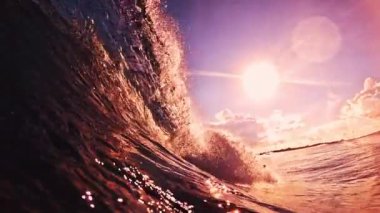 Gün batımında Maldivler 'de bir kıyıda okyanus dalgası kopar.