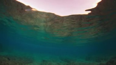 Gün batımında Maldivler 'de bir kıyıda okyanus dalgası kopar.