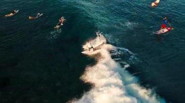 İnsan dalgalarda sörf yapar. Maldivler 'de dalgalarda sörf yapan erkek sörfçünün hava görüntüsü.