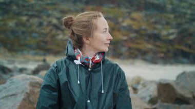 Kayalık arka planda duran zarif gülüşlü beyaz kadın portresi