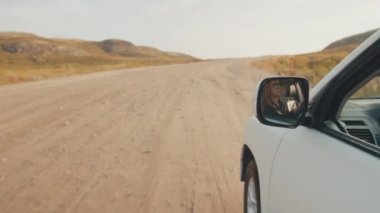 Genç kadın engebeli asfaltsız bir yolda büyük 4x4 'lük arabayı sürüyor.