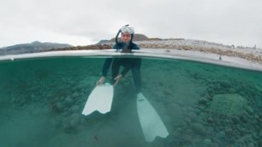 Kuzey Kutbu serbest dalışı. Barents Denizi 'nde beyaz yüzgeçler takan genç bir kadın.
