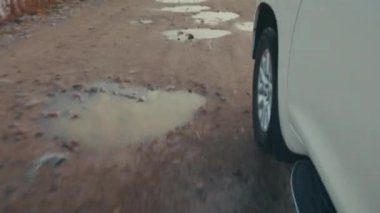 Genç kadın engebeli asfaltsız bir yolda büyük 4x4 'lük arabayı sürüyor.